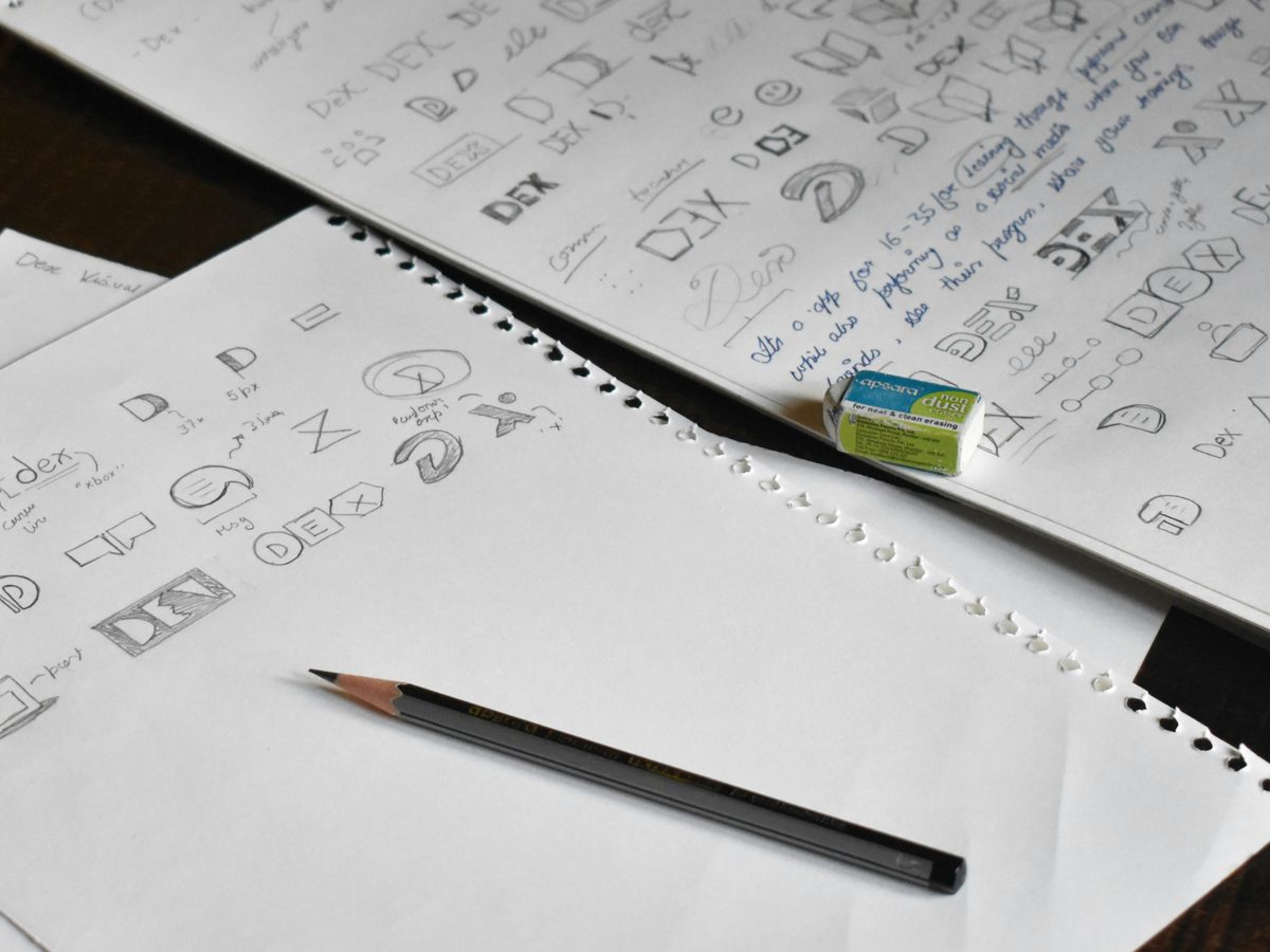 Hand-drawn logo concept sketches in a notebook